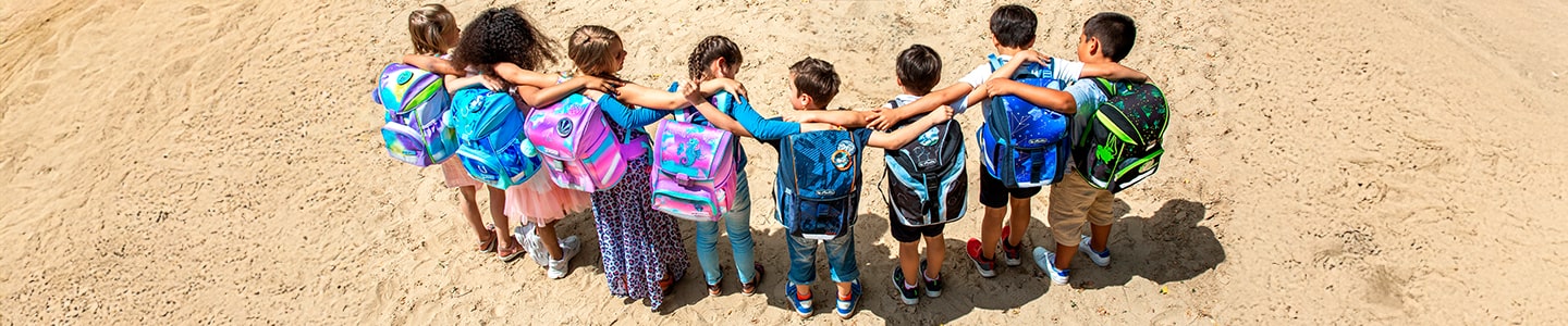 Children with backpacks held by the shoulders